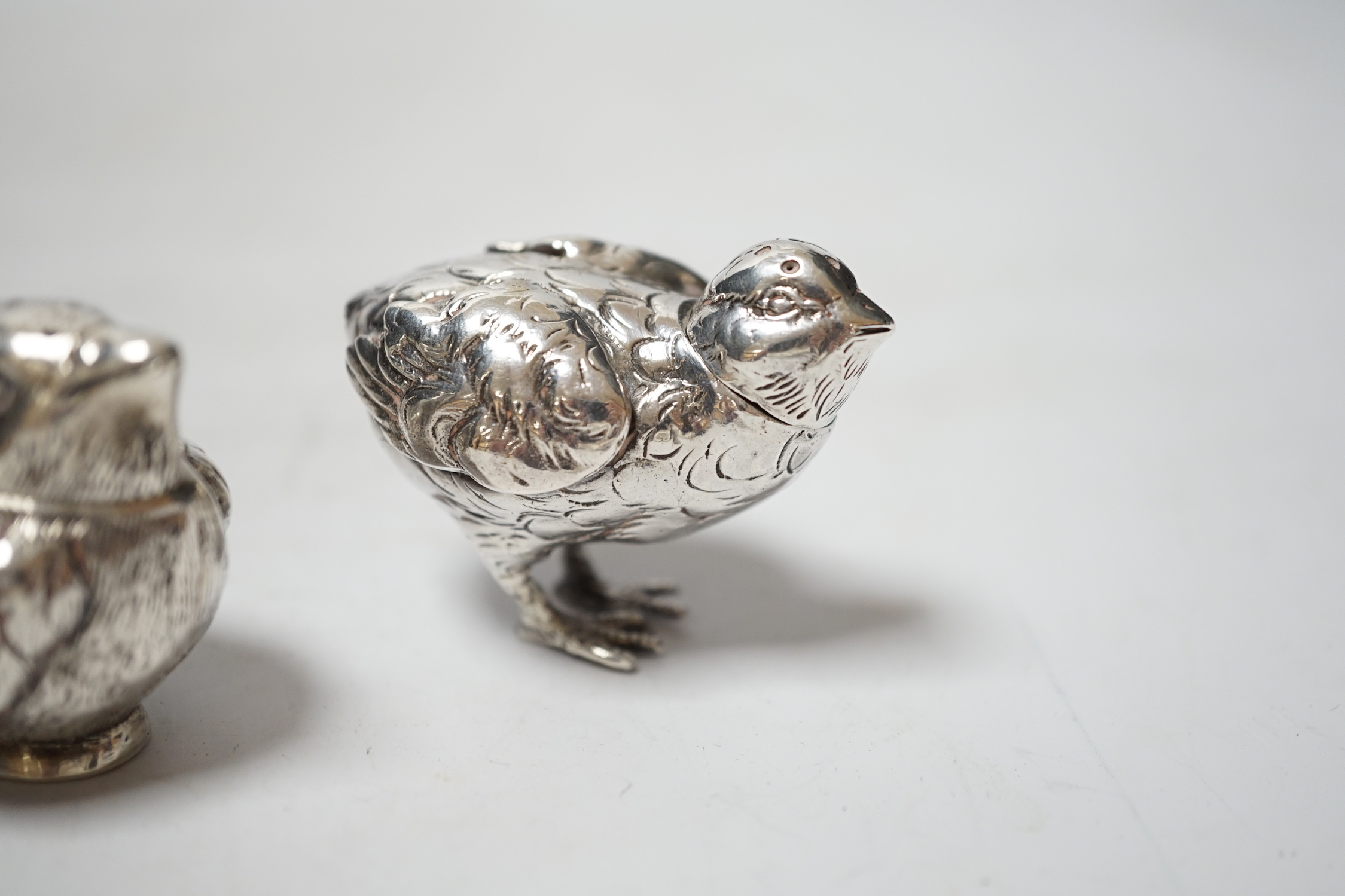 Two novelty silver pepperettes, modelled as chicks, the smallest with import marks for London, 1925, the other with import marks, but no date letter.